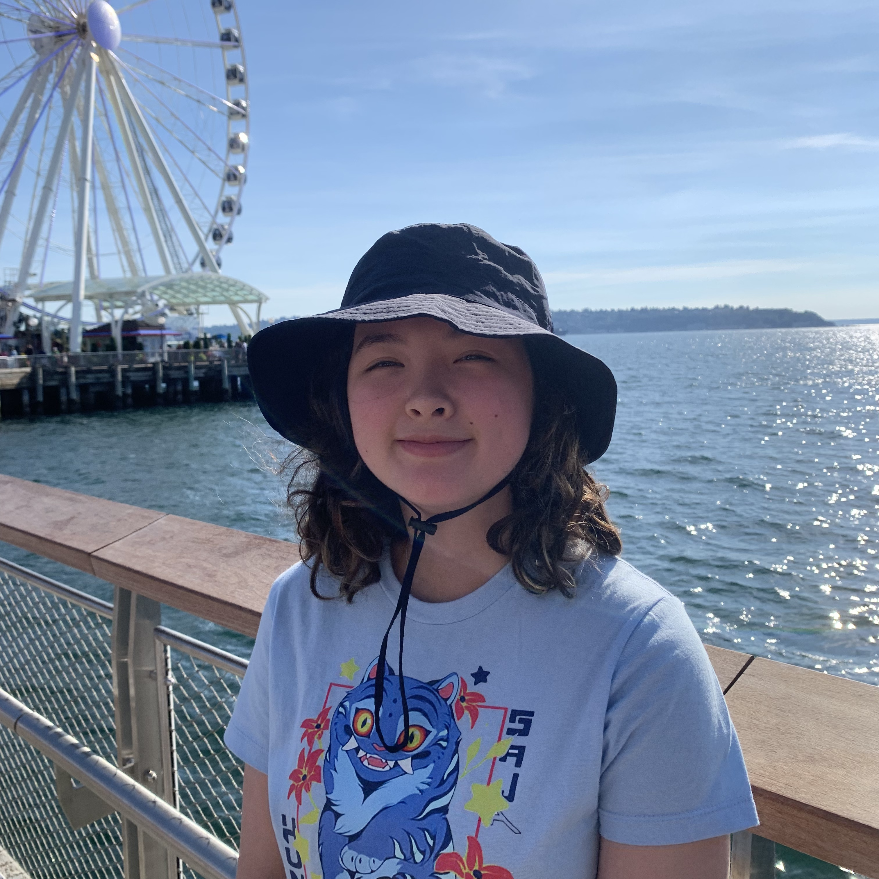 An image of Savannah Garrard in front of the Seattle ferris wheel wearing a bucket hat!