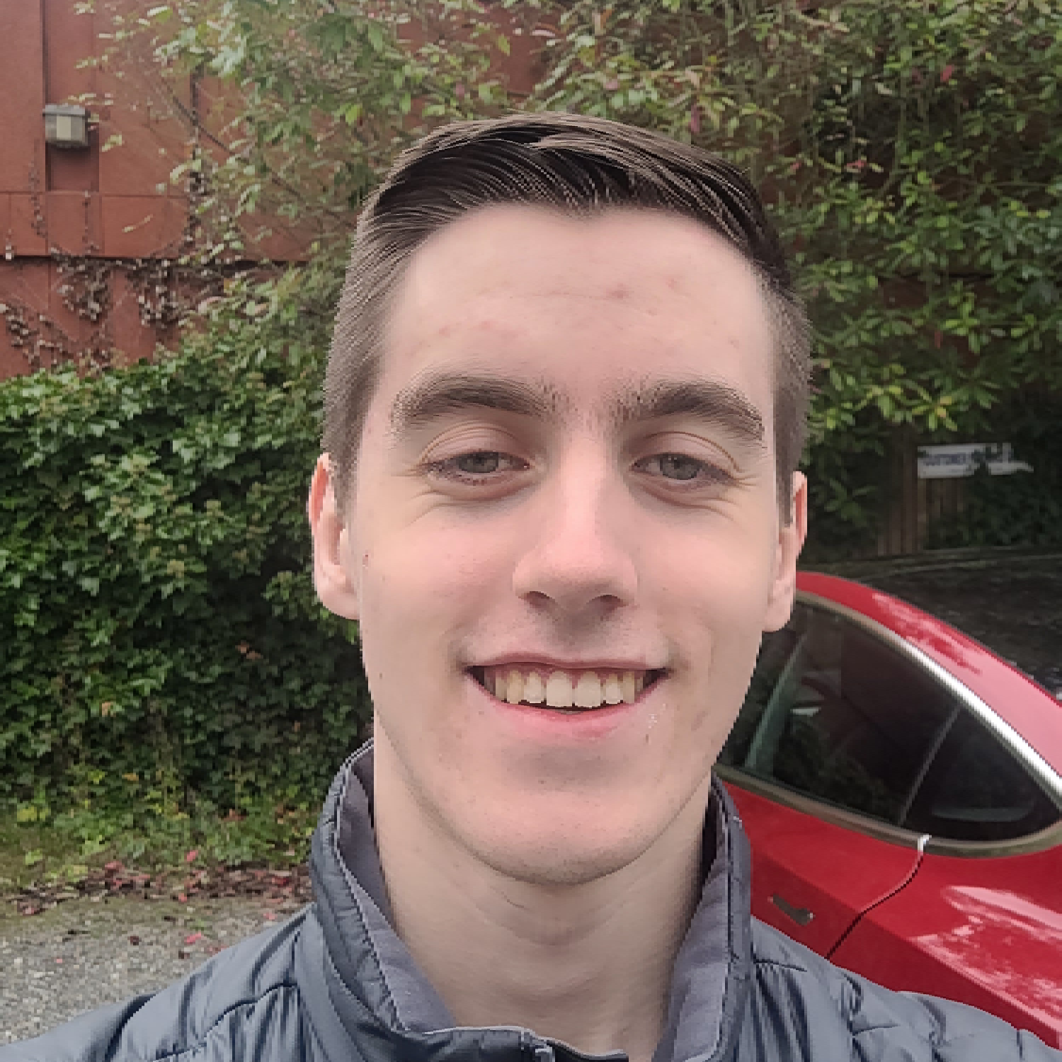 Image of William Baird with a backdrop of bushes and buildings.