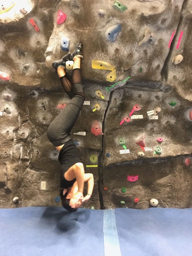 climber hanging upside down by feet