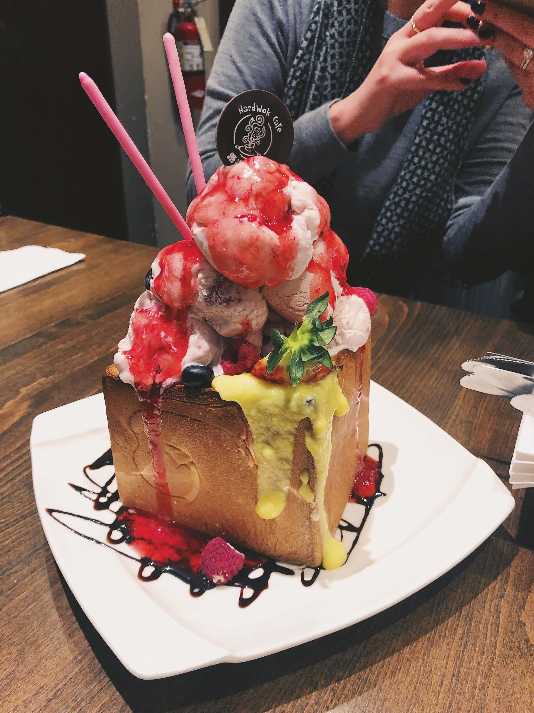 A HUGE chunk of honey
              toast topped with strawberries, ice cream, and a pocky stick.