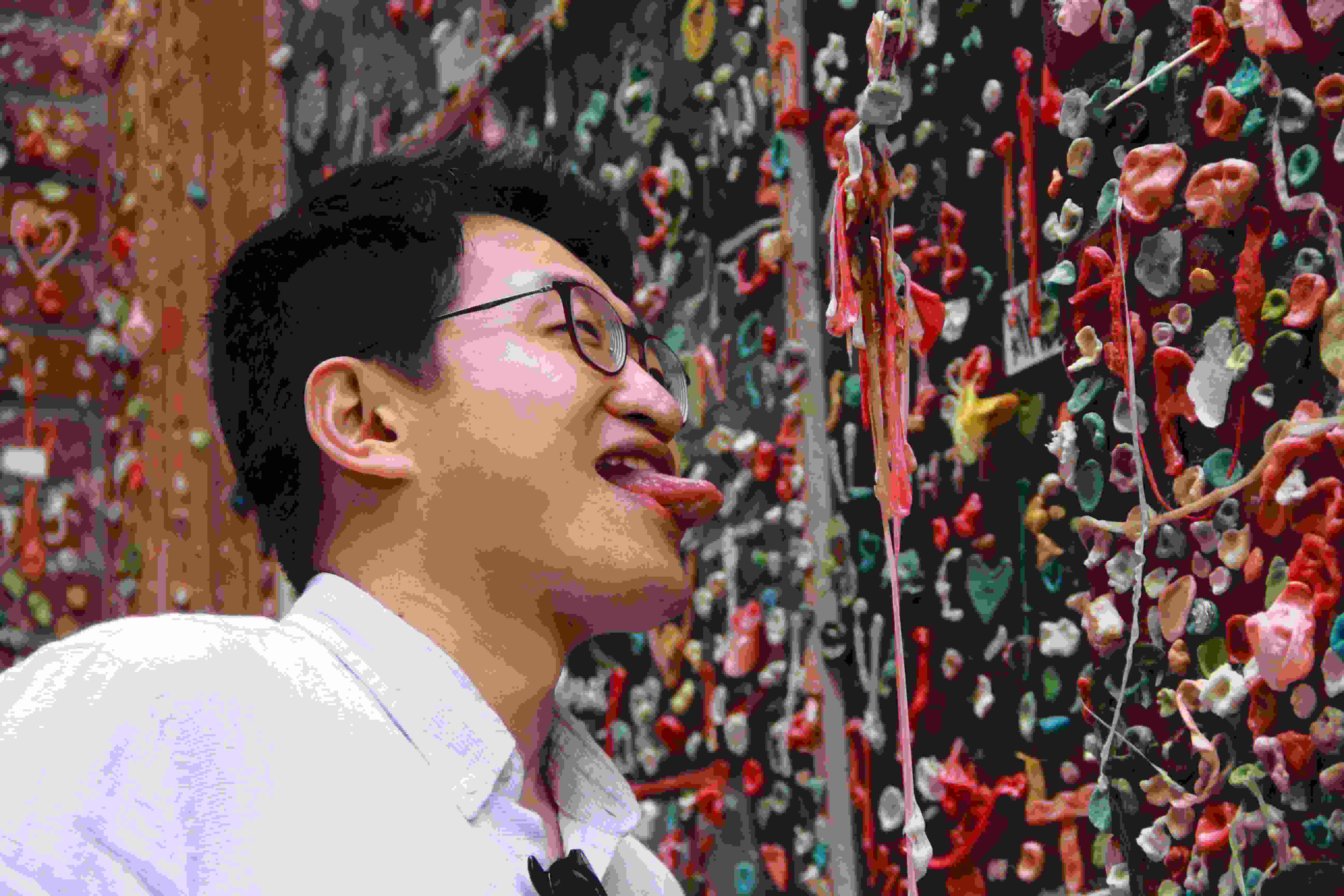 Guy licking gum at the Gum Wall
