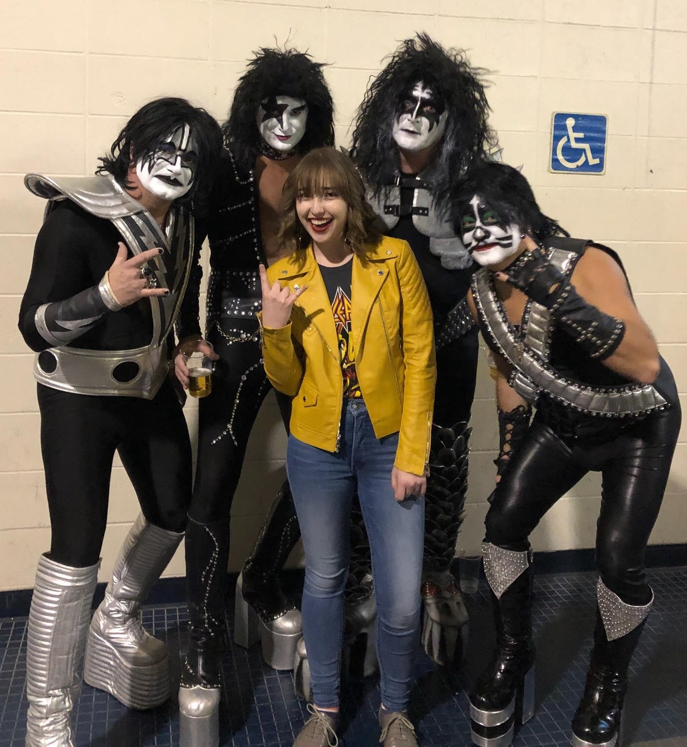 Noelle posing with people dressed as the band Kiss