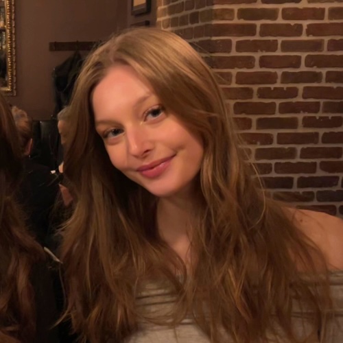 A picture of Saan Popovic sitting at a restaurant smiling.
