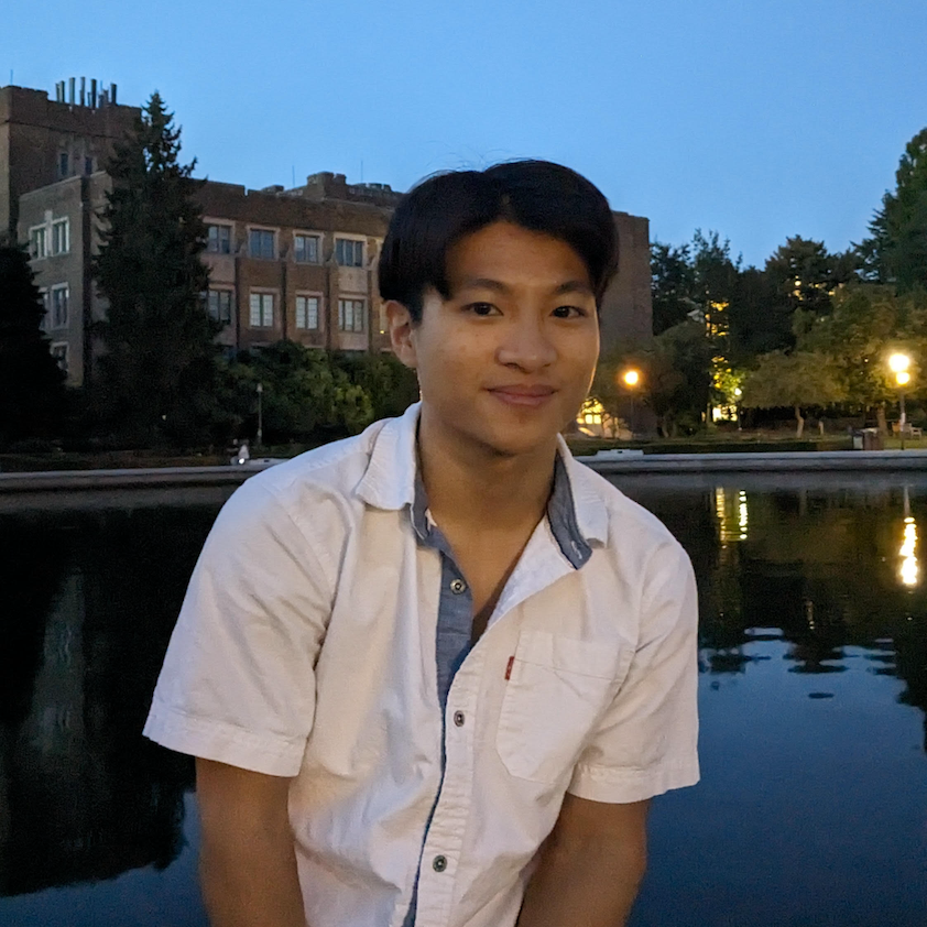 A profile picture of Edison Leung, who is smiling at the camera with
    the UW Drumheller fountain in the background. He has short, dark hair and is wearing a
    white button-up shirt with a blue inner collar. The photo is taken in the evening, with
    lights from the buildings and trees reflecting off a nearby body of water.