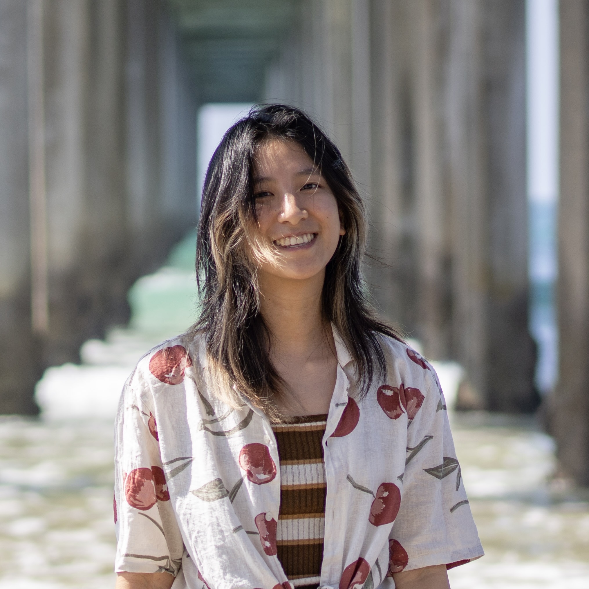 A picture of Alice in front of a bridge and water