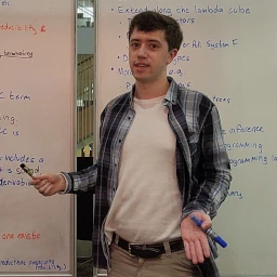 A photo of James presenting at a whiteboard.