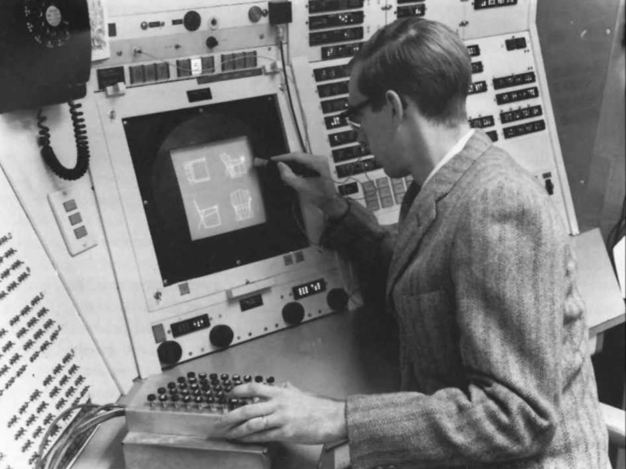 :img A young man sitting at a complex machine covered in buttons--drawing on the screen with a pen, 100%