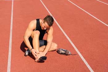 injured runner sitting on a track