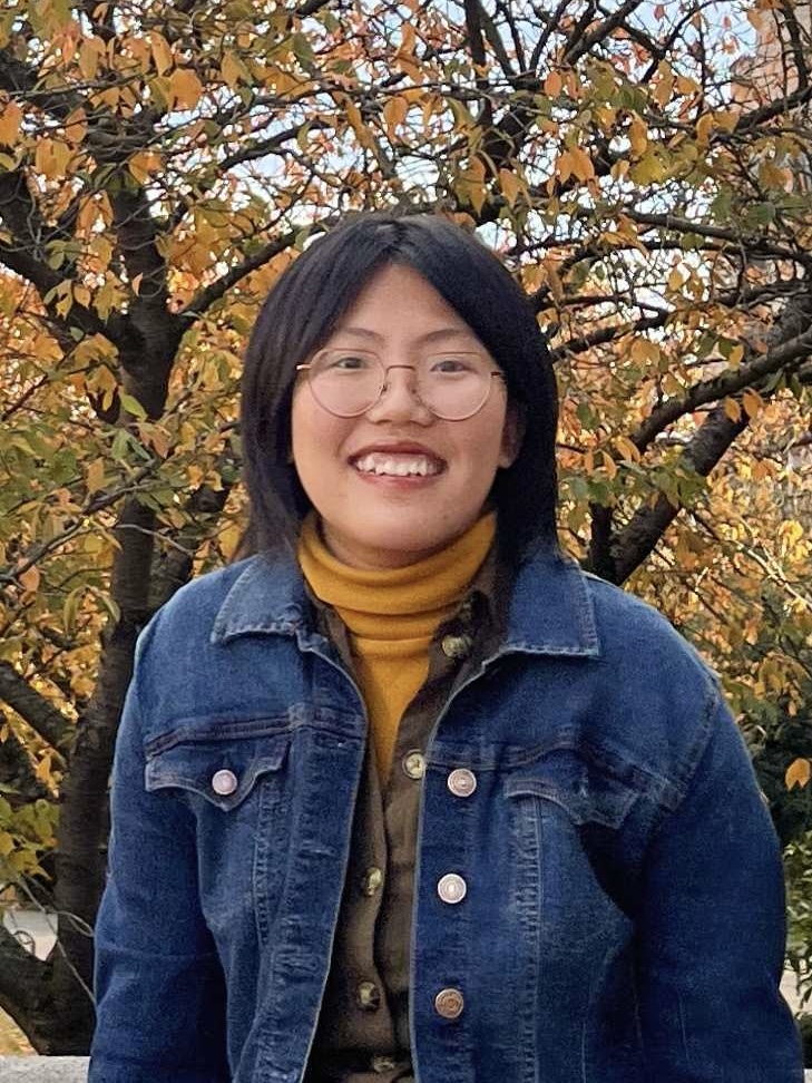 Simona Liao, an east Asian, femme-presenting person with black, straight, short hair wearing a pair of glasses and a blue jeans jacket.