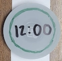 A paper prototype watch face showing the time and green ring.