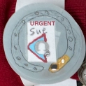 A paper prototype watch face showing the a phone contact named Sue and bold text saying URGENT.