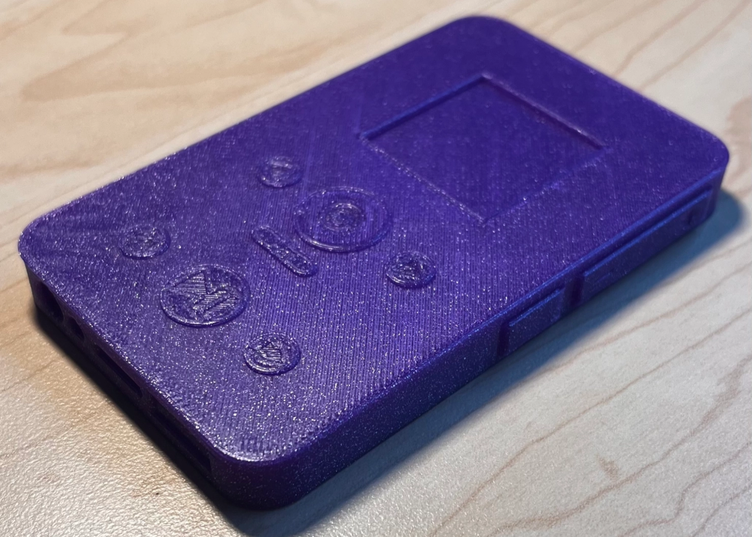 3D printed rectangular device with buttons and a indentation representing a screen