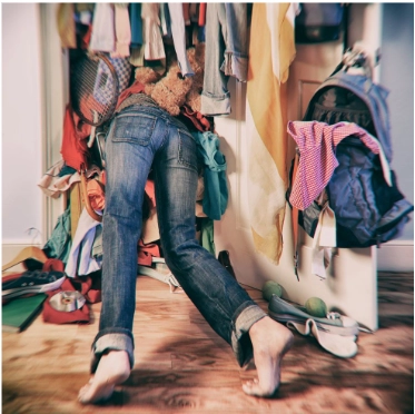 A person falling into their overfull wardrobe