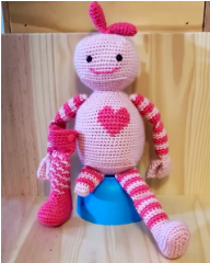 :img A crochet robot with a prosthetic leg and a big heart, 70%, width