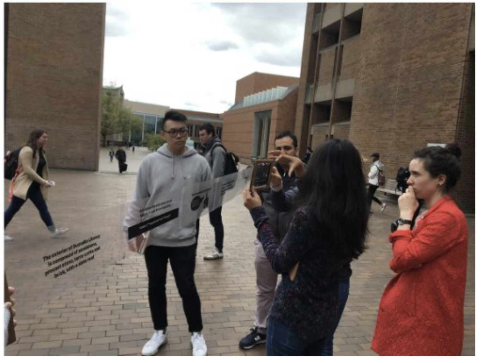 A different person is interacting with the cardboard. It is clear from this viewpoint that the screen is actually a roll of semi-transparent plastic that a wizard is sliding through the screen to update the image