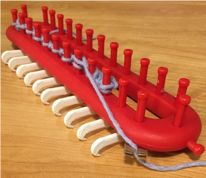 :img Red knitting loom with white hooks to aid accessibility, 45%, width