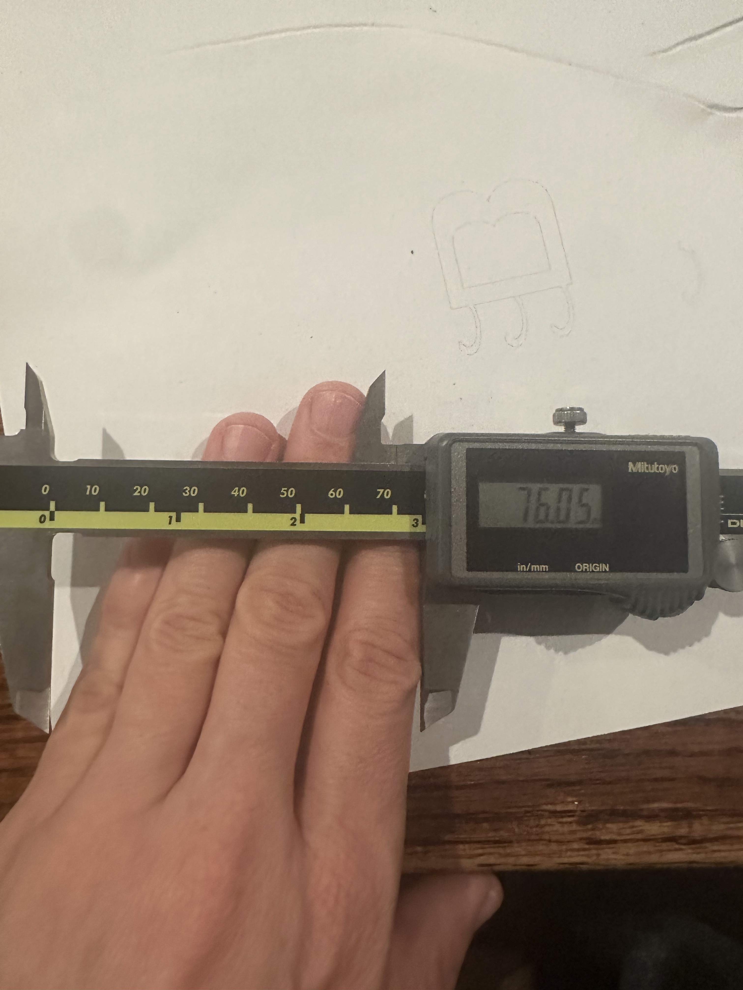 :img Calipers stretch the width of four fingers and show a measurement of about 76mm , 30%, width